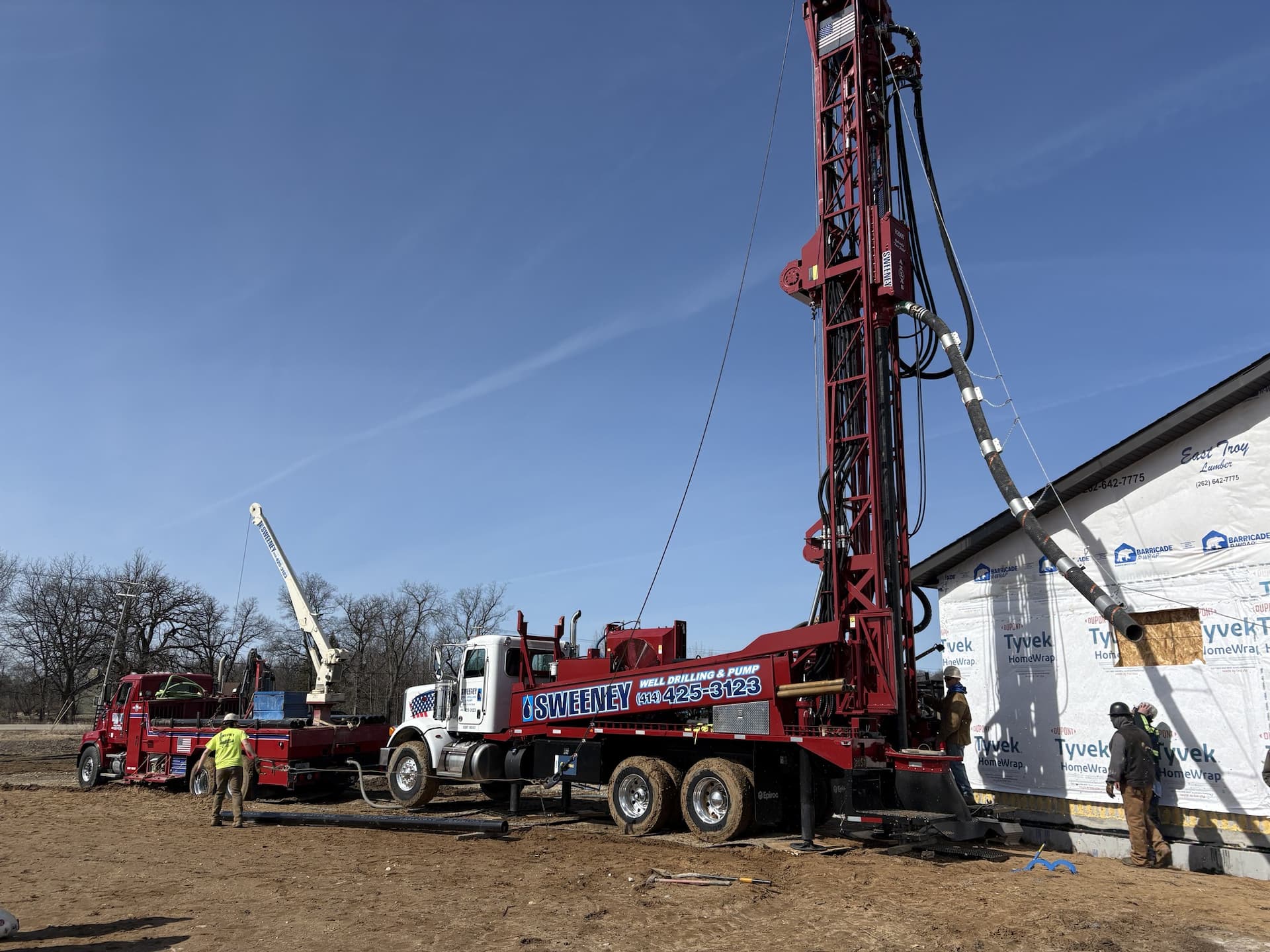 Water well drilling rig completing a residential well